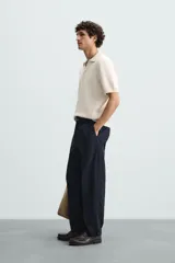 Polo color crema de punto con cuello solapa y abertura frontal en V.