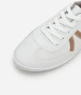 Championes blancos de estilo chutera, con detalles metalizados en color cobre, lazo de cordón y suela baja.