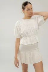 Minifalda marrón de lino con cintura alta y volado en el ruedo.