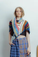 Bufanda triangular tejida a mano en lana y algodón, con diseño multicolor y botón frontal.