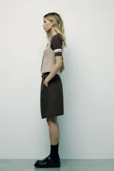 Chaleco color beige de escote recto y tirantes finos. Presenta un falso bolsillo de vivo en el delantero y cierre frontal con botones forrados.