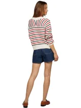 Sweater de punto color crema con rayas horizontales rojas y azul marino. Tiene cuello en V, mangas largas y logo de Tommy Hilfiger bordado en el pecho.