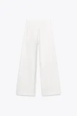 Pantalón de jean celeste de tiro alto y corte wide leg, con bolsillos frontales y traseros, cierre frontal con cremallera y botón metálico.