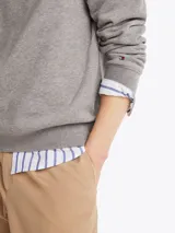 Buzo gris de Tommy Hilfiger con cuello redondo, corte regular y hombros ligeramente caídos. Presenta el logo de la marca estampado en el pecho y un logo bordado en el puño.