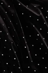 Vestido corto negro de terciopelo con escote barco y mangas largas. Presenta apliques de strass plateados en todo el vestido.