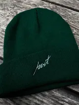 Gorro de lana verde oscuro con dobladillo y bordado blanco con la palabra "Just".