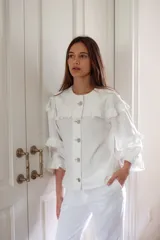 Campera de jean gris oscuro con volados en el frente y las mangas, de corte recto y largo a la cadera.