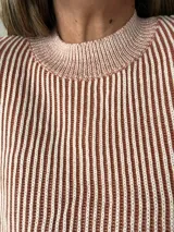 Suéter tejido de corte relajado con diseño a rayas finas en color crudo y verde militar. Tejido suave y abrigado con cuello redondo clásico.