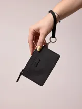 Billetera azul de poliuretano con cierre y correa de mano.