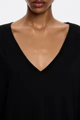 Camiseta blanca de viscosa, corte recto, cuello en V y manga corta ancha.
