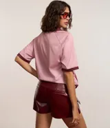 Short pollera de cuero sintético color bordó, con bolsillos delanteros con solapa y cierre frontal con cremallera.
