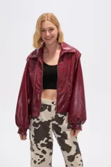 Chaqueta de eco-cuero color bordó, holgada, con cierre frontal, cuello tipo camisa y bolsillos laterales.