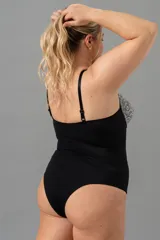 Body negro con puntilla elastizada blanca en busto y cintura. Breteles regulables y broche en entrepierna.