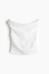 Top blanco de punto, ajustado al cuerpo, con escote Bardot (hombros descubiertos) y frunces laterales que crean un efecto drapeado.