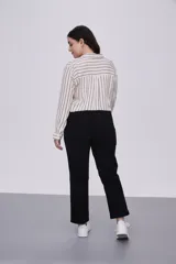 Pantalón negro cropped de calce recto, confeccionado en algodón y spandex, con bolsillos laterales y cintura media.