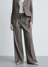 Pantalón de vestir color gris topo, de corte wide leg, tiro alto, con trabillas, cierre frontal con botón, gancho y cremallera, detalle de pinzas y dos bolsillos laterales.