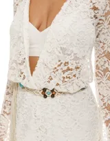 Mono corto de encaje blanco con mangas largas acampanadas, escote en V y cinturón de cordón con cuentas.