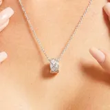 Collar plateado con dije cilíndrico con incrustaciones de strass.