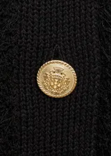 Chaleco negro de tejido de punto con textura, cuello redondo, diseño recto, sin mangas y cierre delantero con botones dorados.