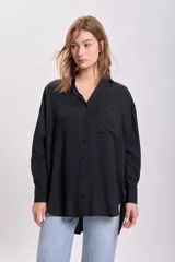 Camisa negra de liocel con cuello clásico, cierre frontal con botones, manga larga y bolsillo de parche en el pecho.