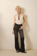 Pantalón de jean negro con tiro medio, calce ajustado y pierna acampanada desde la rodilla.
