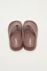 Ojotas marrones con textura en la plantilla y logo de la marca en el lateral.