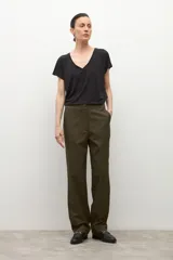 Pantalón de corte recto y tiro medio en color verde oliva, con cierre frontal de cremallera y botón, y bolsillos laterales.