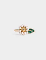 Anillo dorado con dije de flor con pétalos blancos y centro amarillo, y una hoja verde esmaltada.