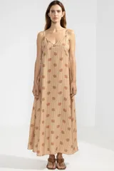 Vestido largo hasta el tobillo con estampado floral color camel, breteles finos y escote en V profundo con detalle de flor en cobre.