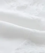 Camisón corto de malla color blanco, con breteles finos ajustables y busto de encaje floral.