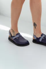 Zuecos azul marino con suela negra y tira trasera estampada en tonos azules.