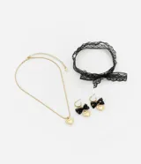 Conjunto de collar con cadena dorada y dije de corazón, gargantilla de encaje negro y aros dorados con dije de corazón y lazo de encaje negro.