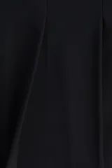 Minifalda negra con cintura estándar, cierre lateral oculto y pliegues de tabla delanteros.