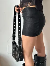 Minifalda plateada con textura brillante y detalle de nudo en la parte delantera.