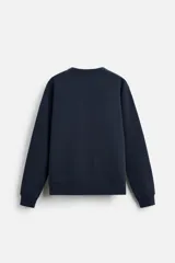 Sudadera negra de corte holgado, cuello redondo y mangas largas con puños acanalados.