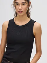 Musculosa crop de algodón, color azul grisáceo, con tejido acanalado (rib) y cuello redondo. Presenta un pequeño logo bordado en el centro del pecho.