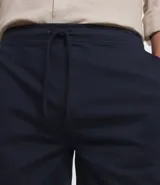 Bermuda masculina color beige de sarga, con cintura elástica ajustable con cordón y bolsillo trasero.