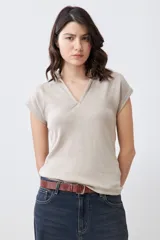 Remera de punto canalé color beige melange, con cuello polo y mangas cortas.
