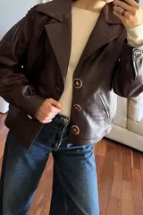 Campera bomber de cuero color vino con cuello de piel sintética desmontable y botones grandes color carey.