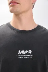 Remera negra de manga corta con estampa de dragón blanco en la espalda y efecto lavado.