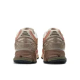 Zapatillas New Balance modelo 1906, color crema con detalles en verde oliva, salmón y marrón.