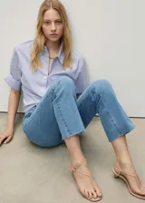 Pantalón de jean celeste de corte flare con tiro medio y bajo desflecado.