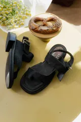 Sandalias negras de cuero con plataforma y hebilla lateral.