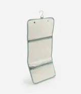 Neceser tipo hotel con estampa de rayas verticales en tonos celeste y blanco. Cuenta con asa superior, cierre con solapa y gancho metálico dorado para colgar. Decorado con aplique de estrella de mar dorada.