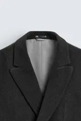 Abrigo corto regular fit color gris oscuro. Cuello con solapas de pico y manga larga acabada en puño con botón. Bolsillos de solapa en cadera y detalle de bolsillo interior. Bajo con abertura en centro espalda. Cierre frontal de botonadura.