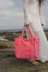 Bolso tipo tote color fucsia, 100% algodón, con diseño drapeado, moña fija y grifa de acrílico Cilento.
