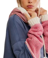 Hoodie oversized color azul desgastado con capucha y bolsillo canguro. Presenta un cuello y puños de tejido de punto con patrón a rombos en rojo y blanco, y cordones gruesos de color crema.