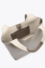 Bolso shopper de hombro color marrón oscuro, con doble tira ancha, bolsillo interior con cierre mediante cremallera metálica y cierre imantado.