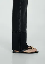 Pantalón de jean negro con corte recto, tiro medio, cinco bolsillos y ruedo con vuelta.