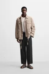 Pantalón de lino color marrón oscuro, de corte recto y relaxed fit. Tiene cintura elástica ajustable con cordón, bolsillos frontales y traseros de parche.